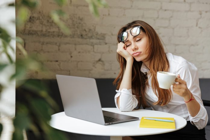 Portrait,Of,A,Tired,Young,Businesswoman,Sitting,At,The,Table
